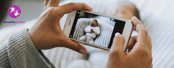 Mother snapping a photo of her newborn Çocuklar ve sosyal medya