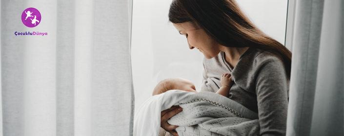 Mother holds newborn boy on her arms while she feeds him ninni danalı bebek